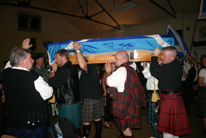 The coffin leaves the hall